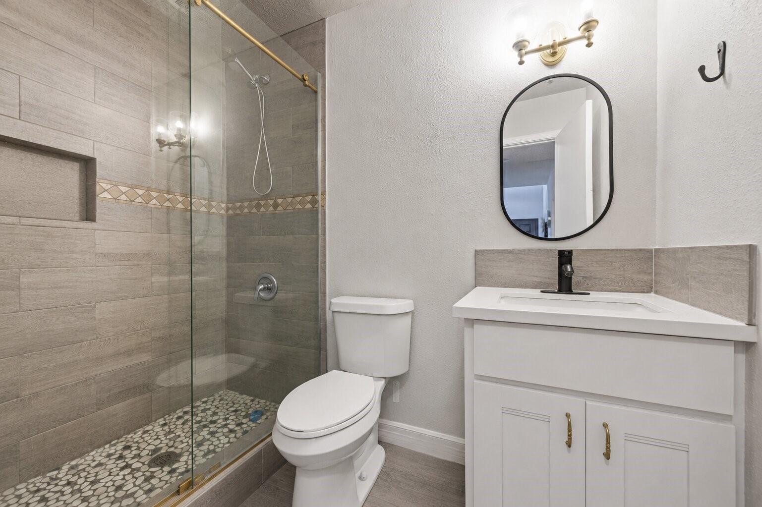 18446 North Willow Bluff Road Katy, TX 77449 - Photo 25 of 33 Modern bathroom featuring a glass-enclosed shower with stylish tilework, a sleek vanity with an oval mirror, and elegant lighting.