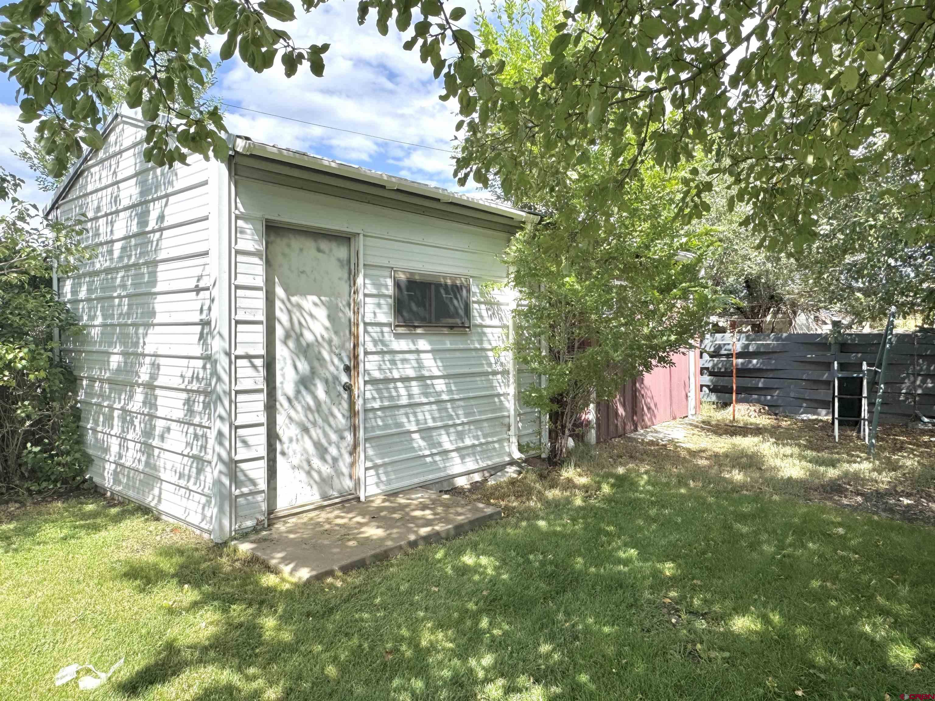 113 Conejos Street Romeo, CO 81148 - Photo 13 of 36 a backyard of a house with table and chairs