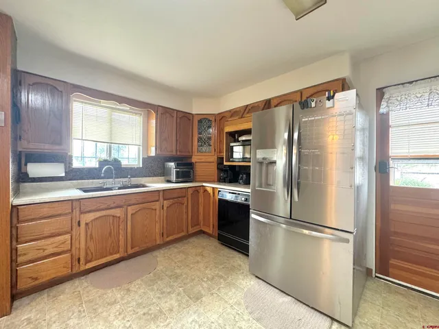 a kitchen with stainless steel appliances granite countertop a refrigerator and a sink