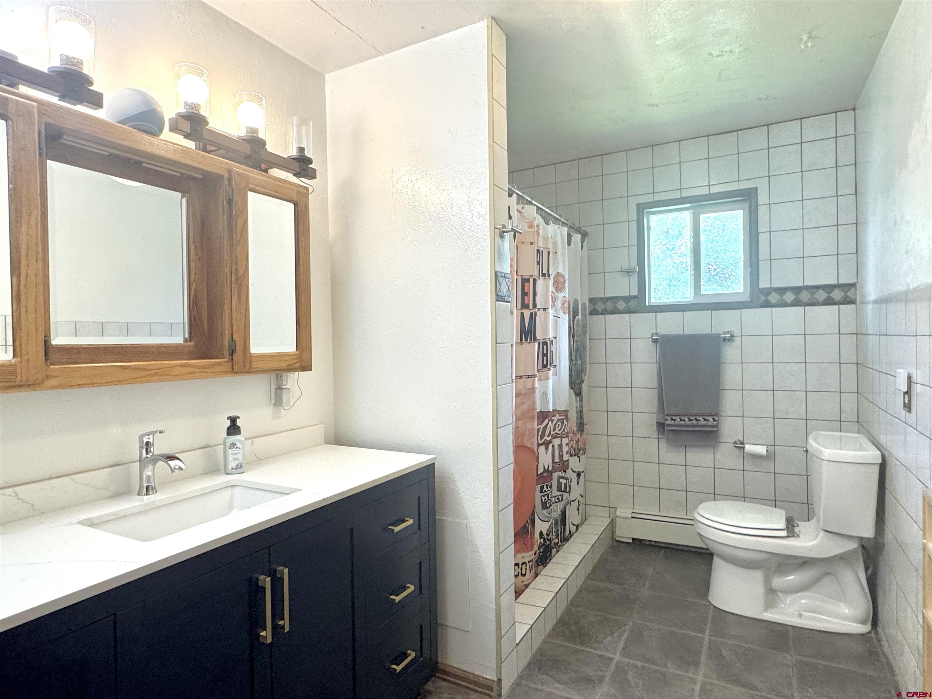 113 Conejos Street Romeo, CO 81148 - Photo 20 of 36 a bathroom with a double vanity sink toilet and shower