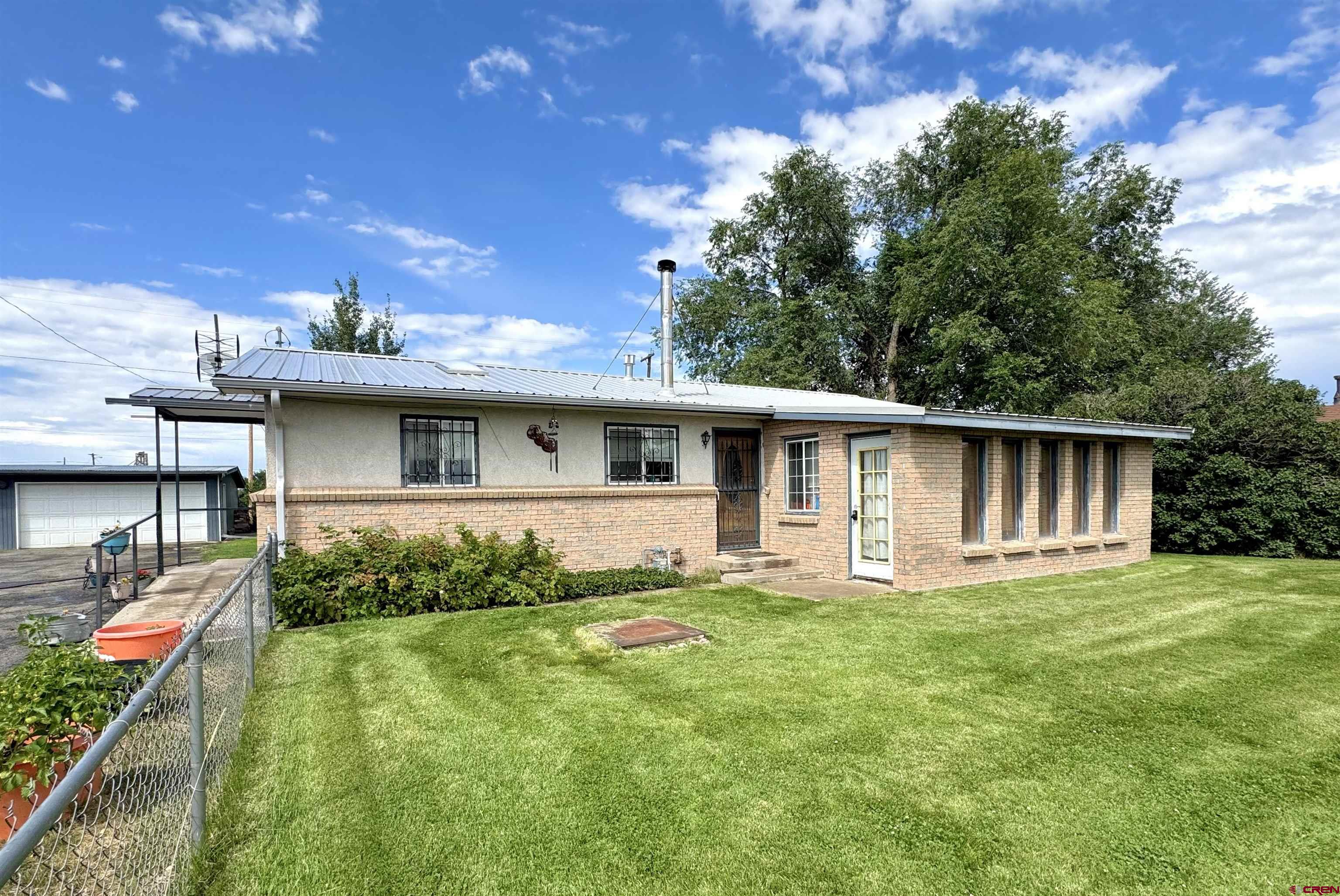 113 Conejos Street Romeo, CO 81148 - Photo 2 of 36 a front view of house with yard and outdoor seating