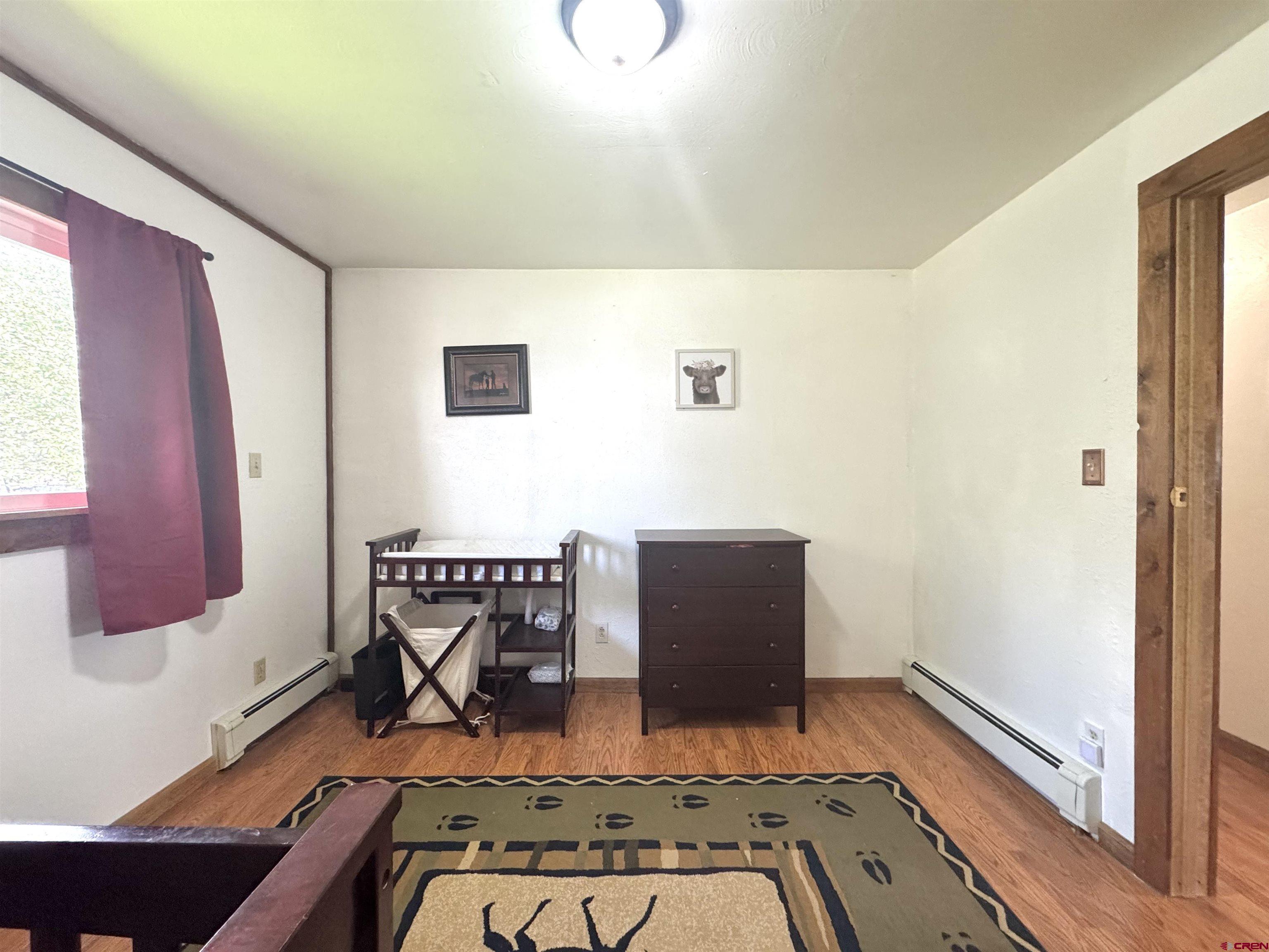 113 Conejos Street Romeo, CO 81148 - Photo 30 of 36 a view of room with window and wooden floor