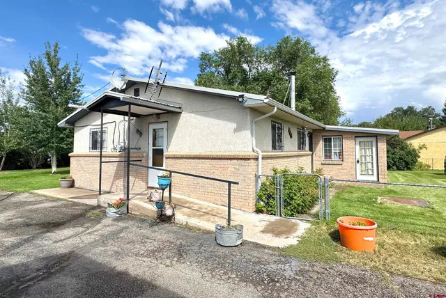 a white house that has a tree in the background