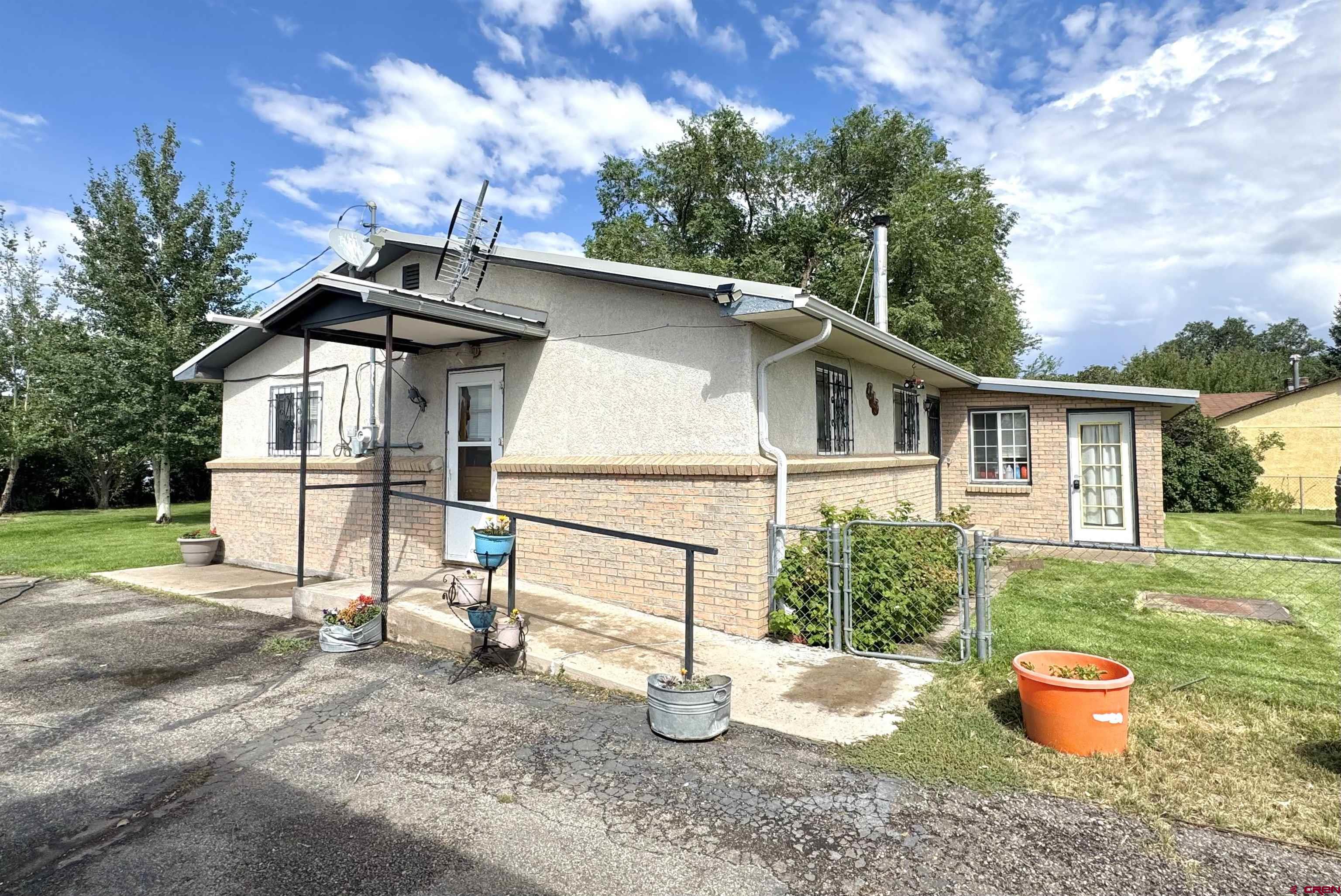 113 Conejos Street Romeo, CO 81148 - Photo 4 of 36 a white house that has a tree in the background