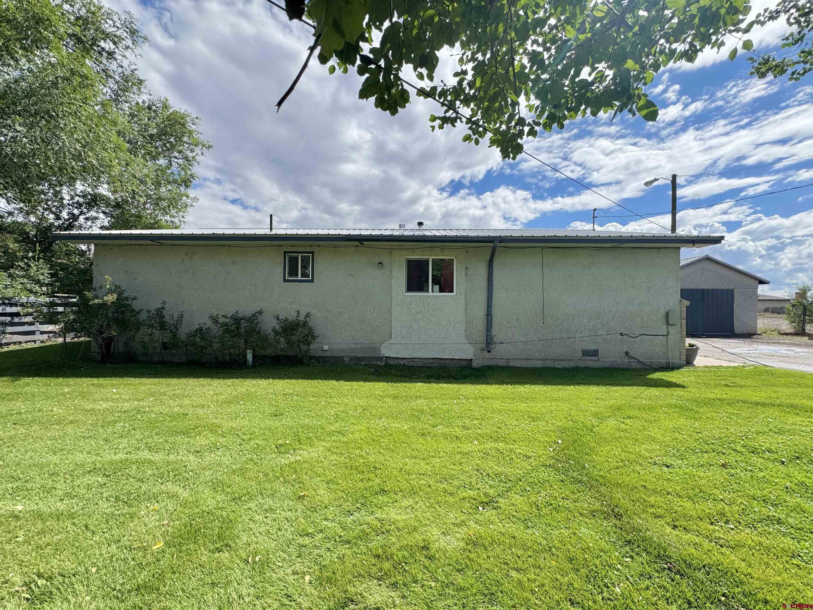 113 Conejos Street Romeo, CO 81148 - Photo 6 of 36 a backyard of a house with lots of green space