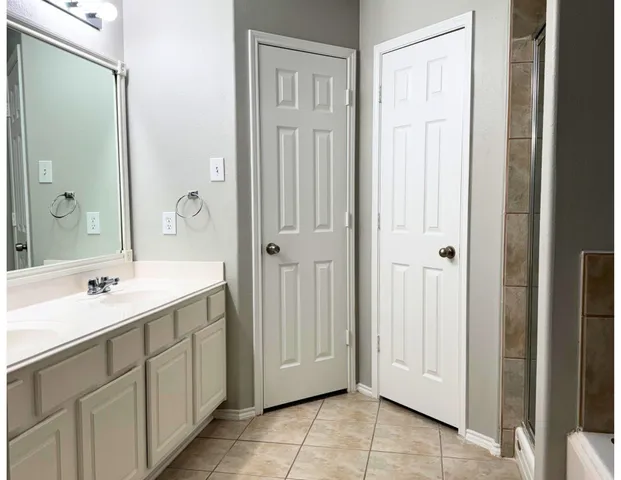 a spacious bathroom with a mirror sink and