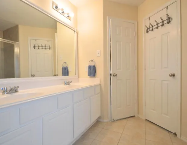 a bathroom with a double vanity sink and mirror