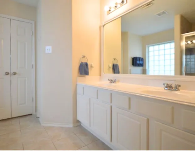 a bathroom with a double vanity sink and a mirror
