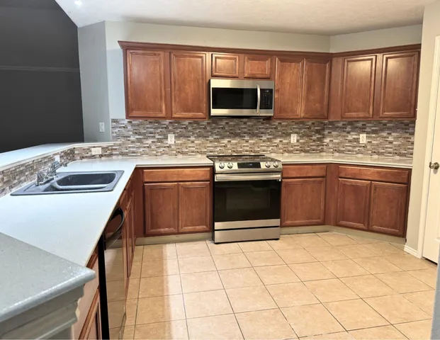 a kitchen with stainless steel appliances granite countertop a sink stove and cabinets