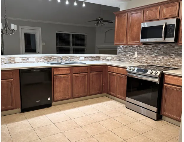 a kitchen with stainless steel appliances granite countertop a sink and a stove