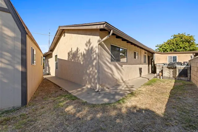 a view of a house with backyard and a tree