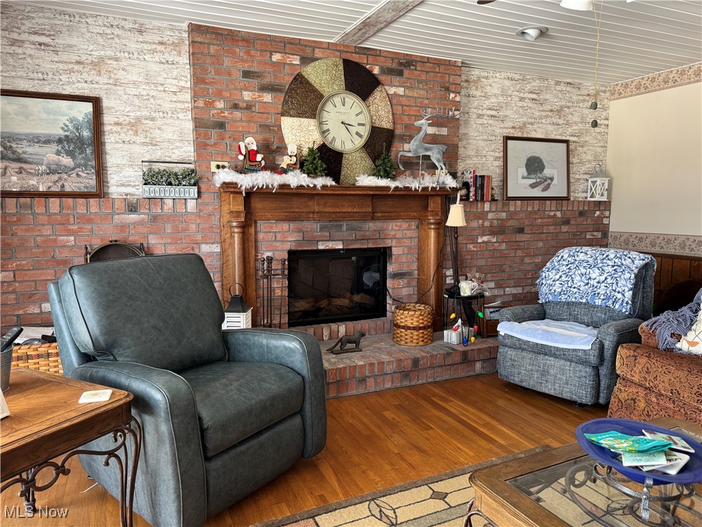 10004 Candy Road Cambridge, OH 43725 - Photo 6 of 20 Living area with hardwood / wood-style floors, a fireplace, and a wainscoted wall