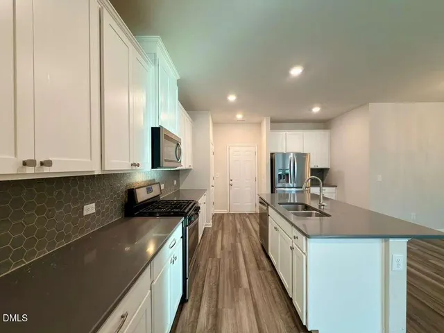 a kitchen with stainless steel appliances granite countertop a stove a sink and a microwave