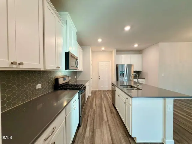 a kitchen with stainless steel appliances granite countertop a stove a sink and a refrigerator