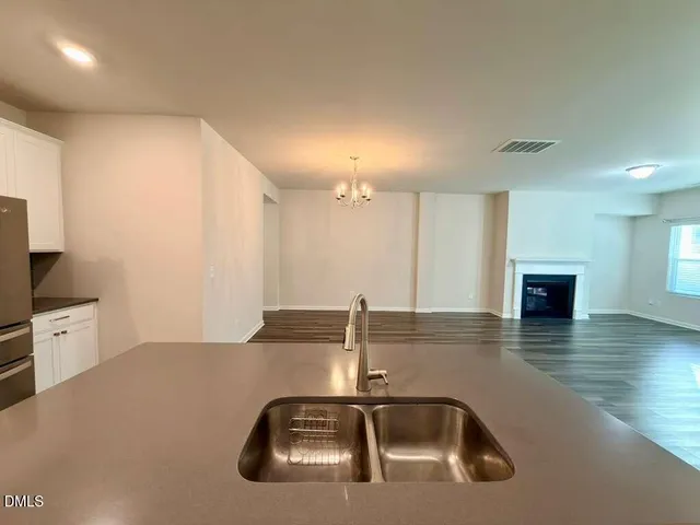 a kitchen with a sink and wooden floor