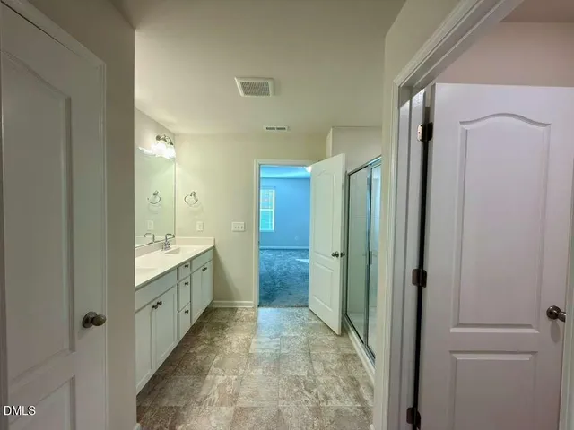 a bathroom with a granite countertop sink mirror vanity and shower