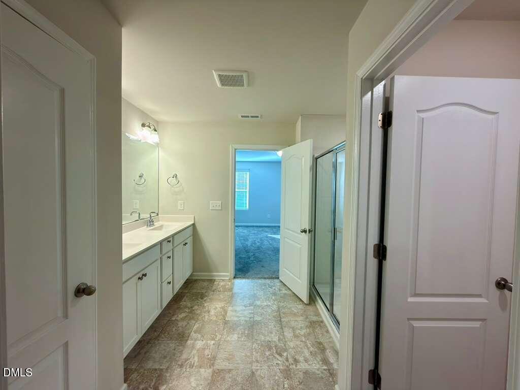 1152 Chestnut Bluff Run Apex, NC 27502 - Photo 22 of 35 a bathroom with a granite countertop sink mirror vanity and shower