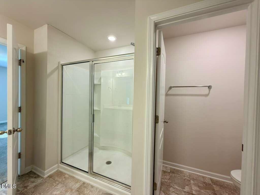 1152 Chestnut Bluff Run Apex, NC 27502 - Photo 23 of 35 a bathroom with a glass shower door