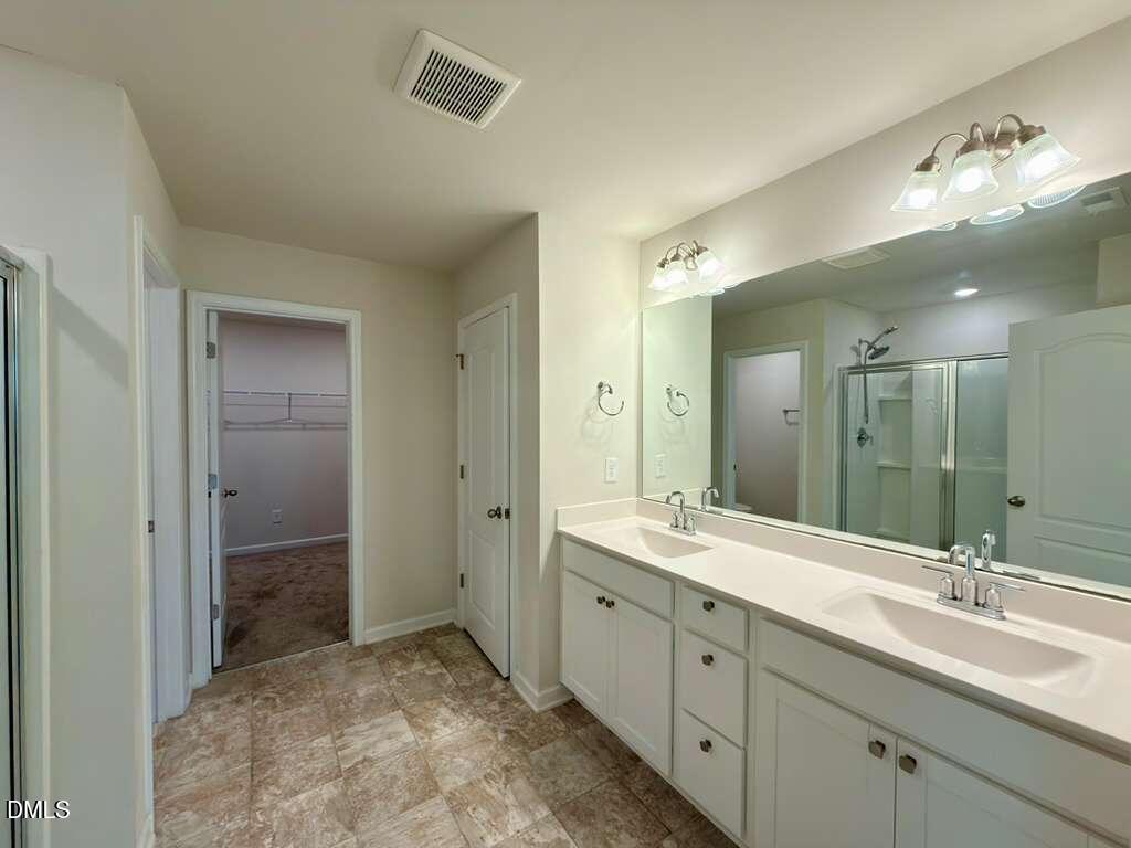 1152 Chestnut Bluff Run Apex, NC 27502 - Photo 24 of 35 a spacious bathroom with a granite countertop sink a mirror and a shower