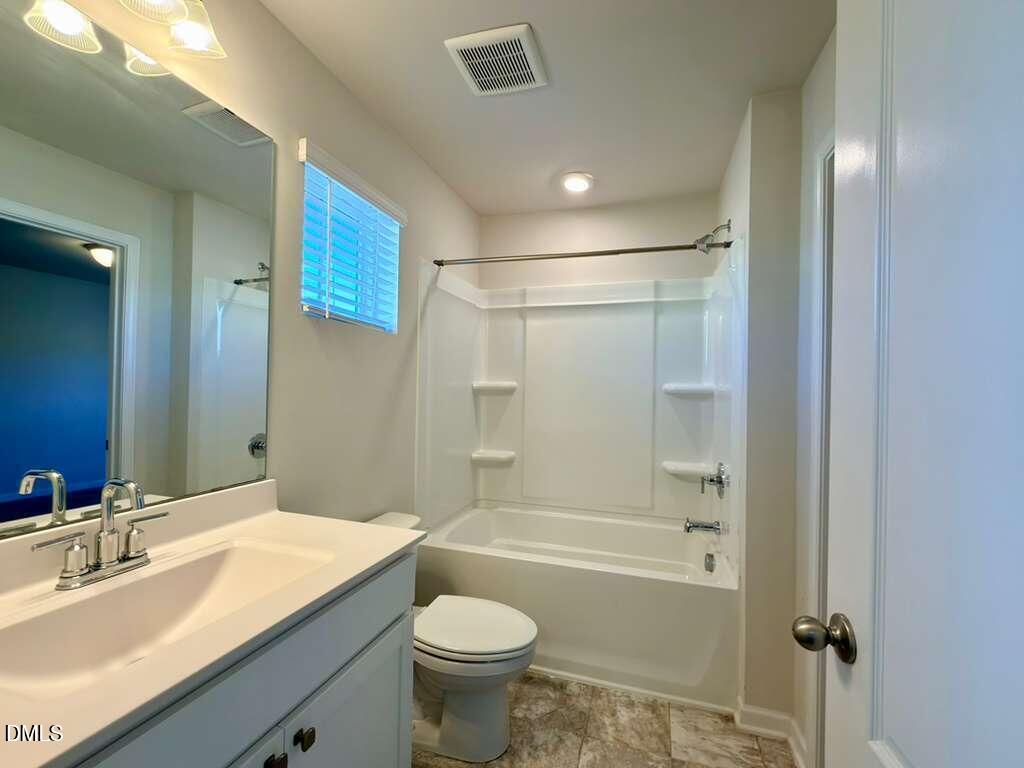 1152 Chestnut Bluff Run Apex, NC 27502 - Photo 29 of 35 a bathroom with a granite countertop sink toilet mirror and bathtub