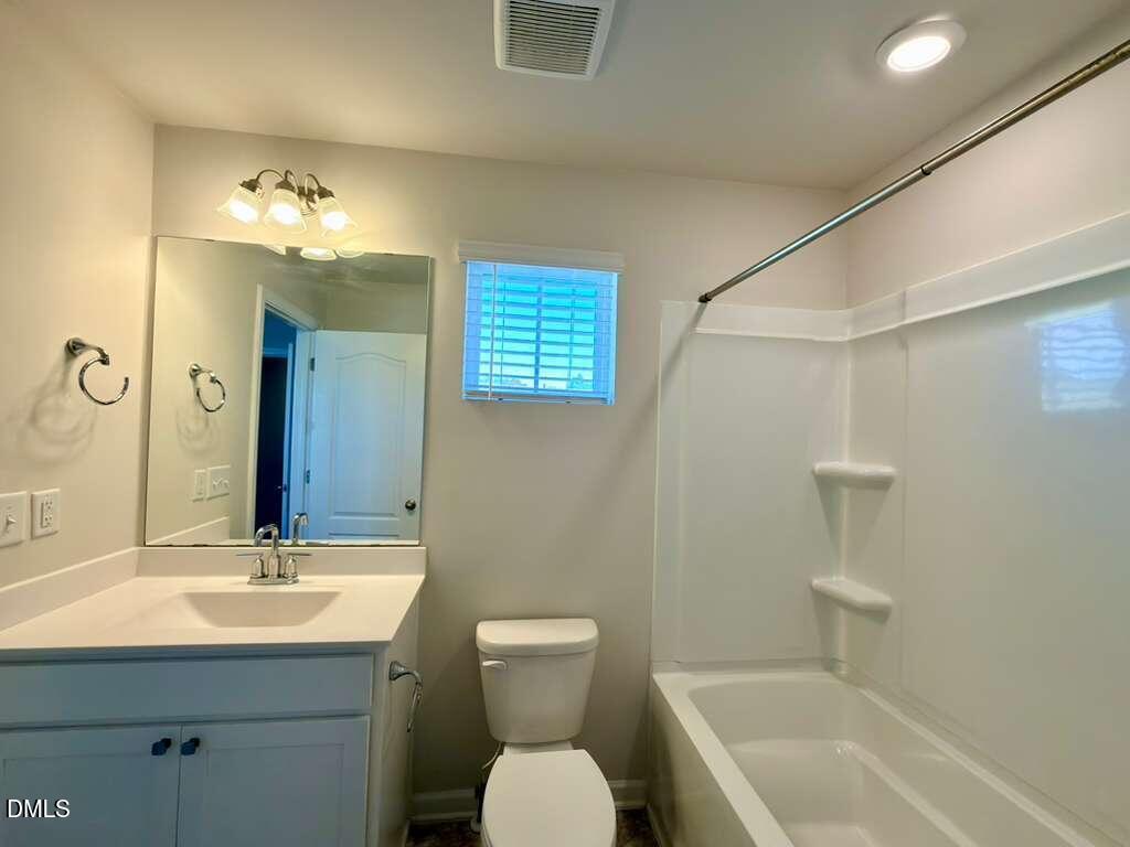 1152 Chestnut Bluff Run Apex, NC 27502 - Photo 30 of 35 a bathroom with a toilet sink and mirror