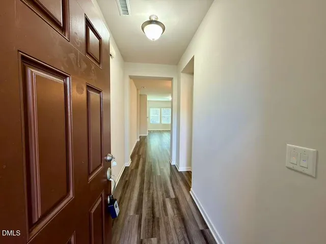 a view of a hallway with wooden floor and staircase