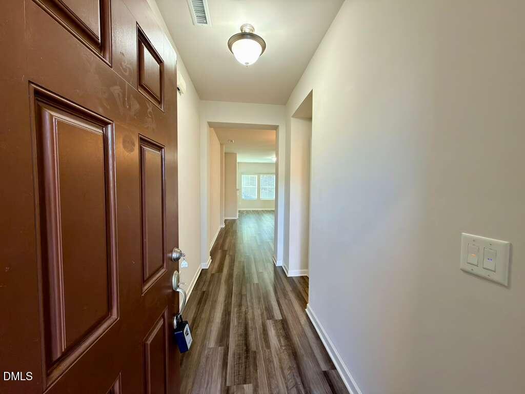 1152 Chestnut Bluff Run Apex, NC 27502 - Photo 4 of 35 a view of a hallway with wooden floor and staircase