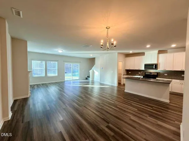 a view of a kitchen with cabinets and wooden floor