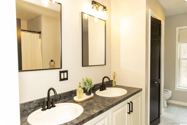a bathroom with double vanity sinks and a mirror