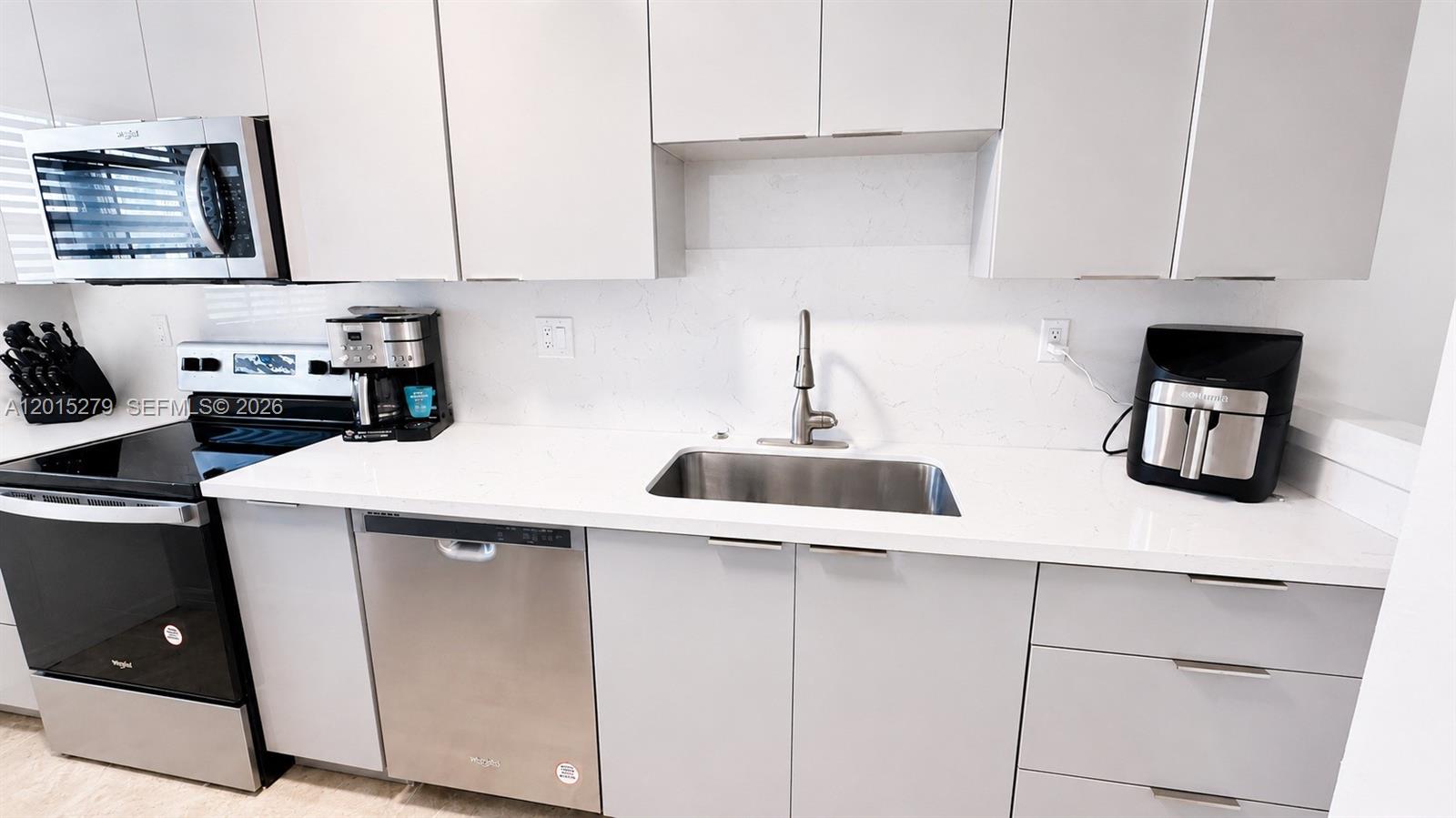 5339 Treetops Drive, Unit 5339 Naples, FL 34113 - Photo 19 of 20 a kitchen with stainless steel appliances a sink and cabinets