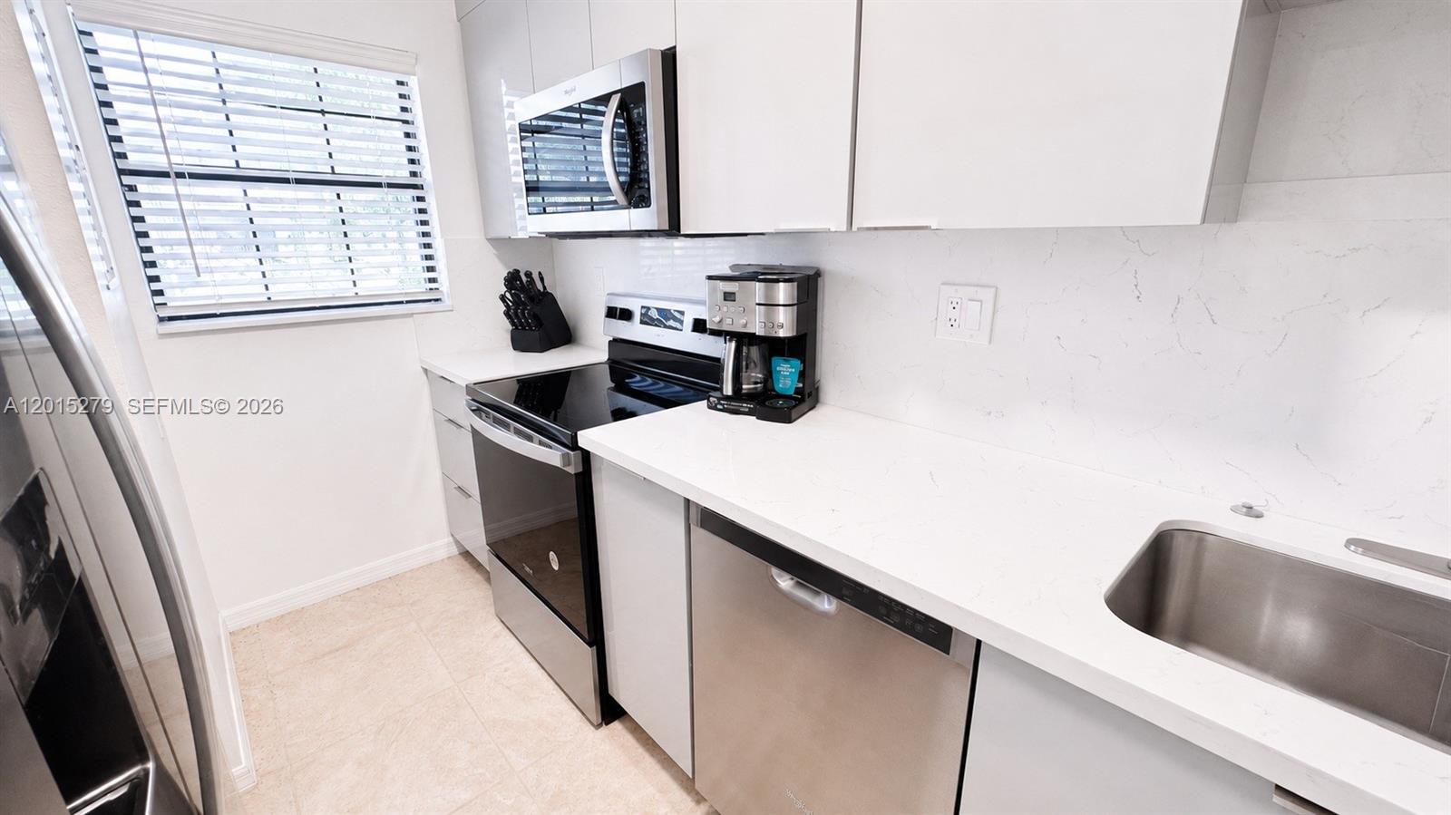 5339 Treetops Drive, Unit 5339 Naples, FL 34113 - Photo 7 of 20 a kitchen with a cabinets and white appliances