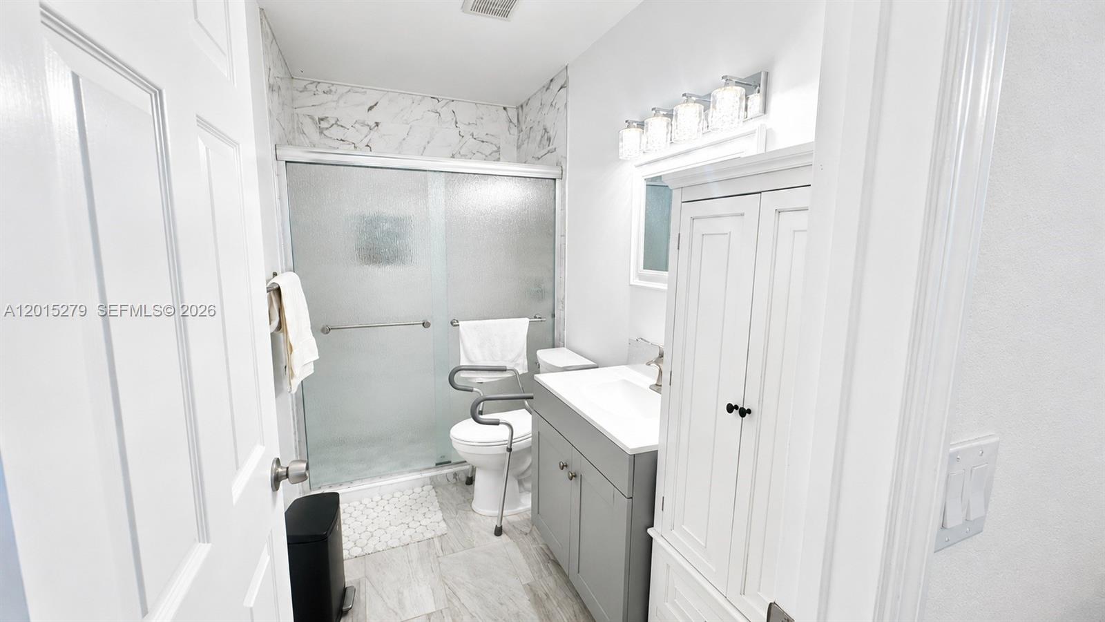 5339 Treetops Drive, Unit 5339 Naples, FL 34113 - Photo 8 of 20 a bathroom with a granite countertop sink toilet and shower