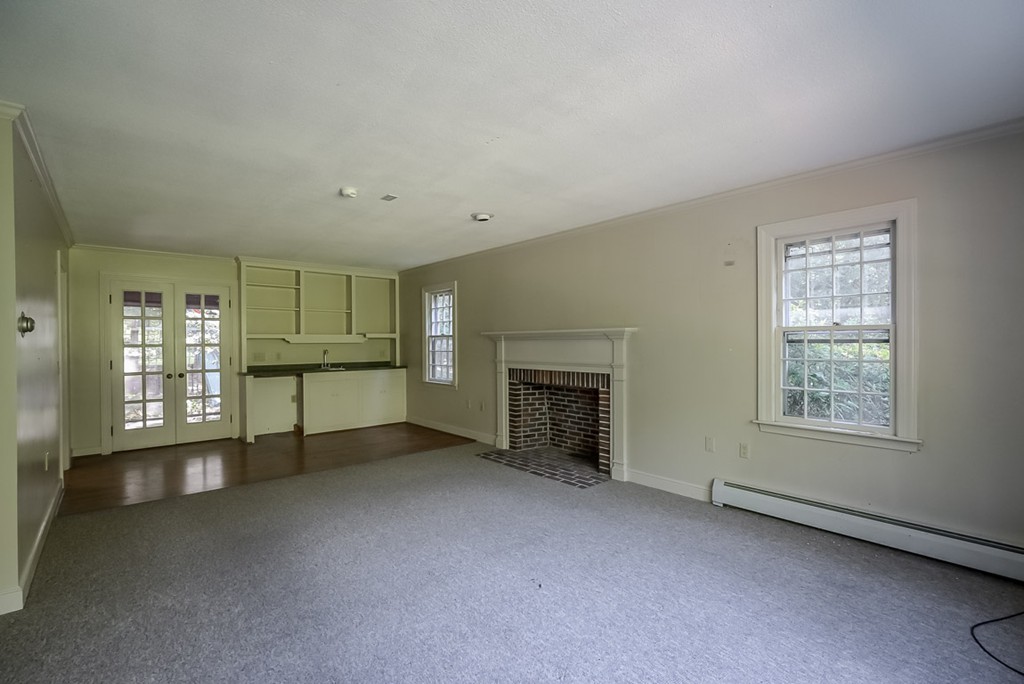 413 Harvard Road Bolton, MA 01740 - Photo 8 of 25 an empty room with fireplace and windows