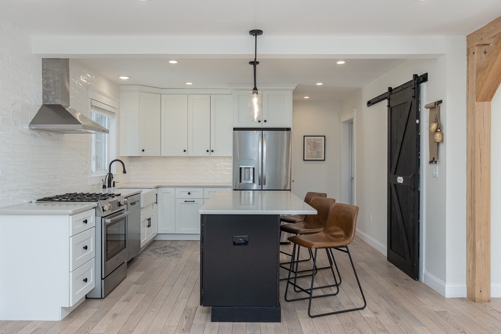 5 Mill Street Dunstable, MA 01827 - Photo 5 of 42 a kitchen with stainless steel appliances granite countertop a refrigerator oven a sink dishwasher and white cabinets with wooden floor