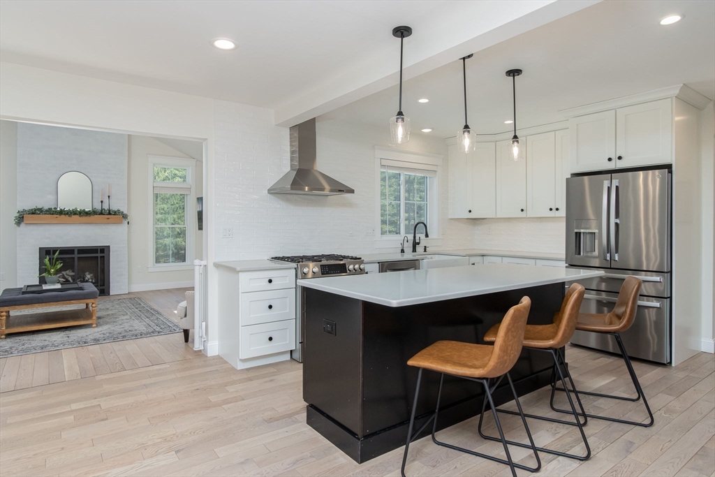 5 Mill Street Dunstable, MA 01827 - Photo 7 of 42 a kitchen with stainless steel appliances a stove a sink a refrigerator a center island and a fireplace