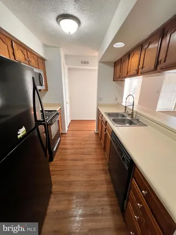 a kitchen with stainless steel appliances granite countertop a sink a stove top oven a counter space and cabinets