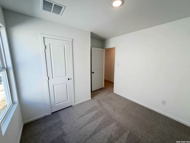 an empty room with windows and closet