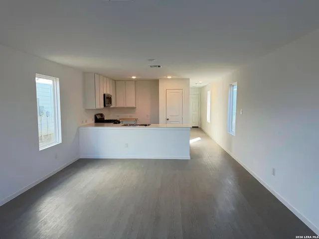 a large kitchen with cabinets counter space a sink and a window