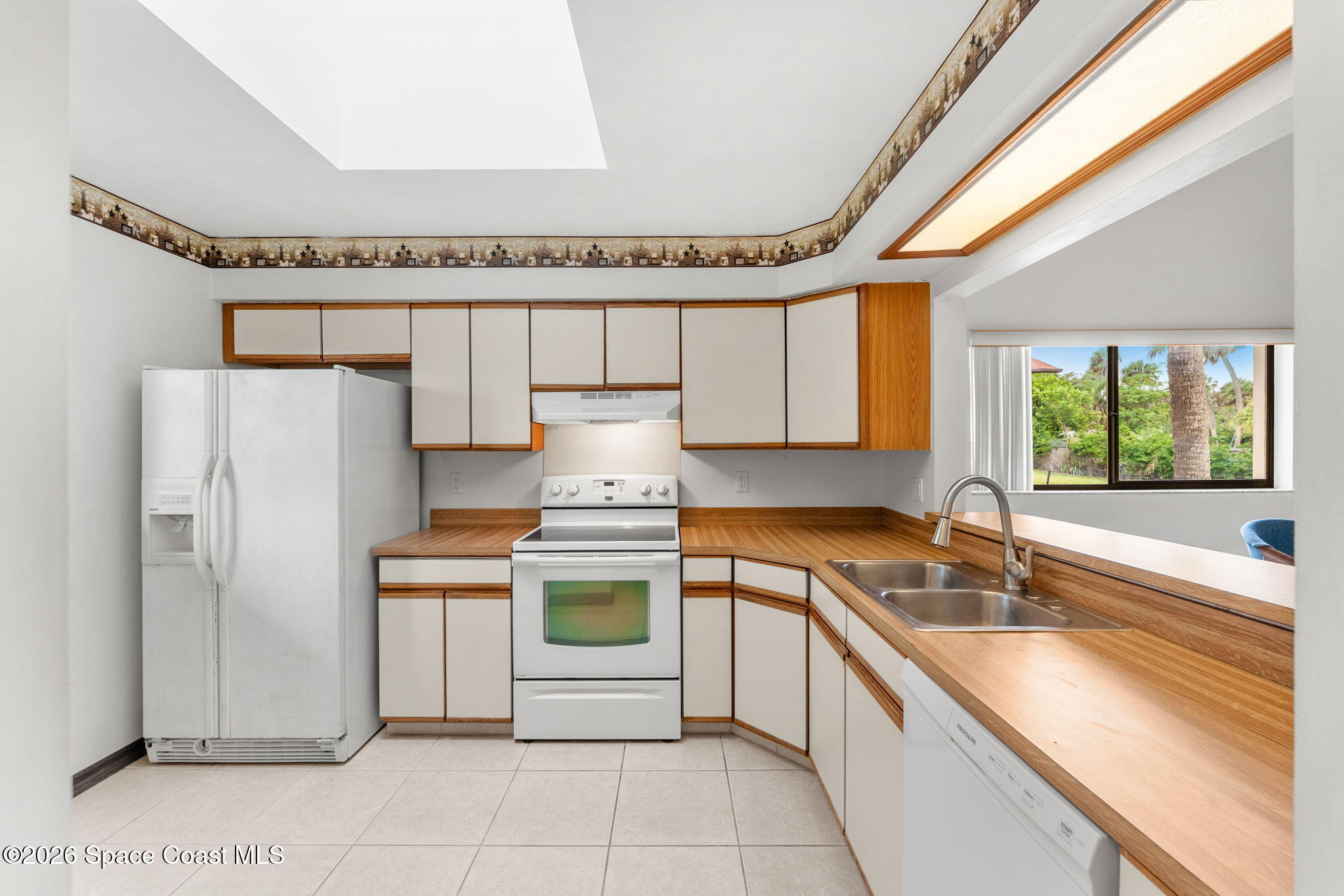 3121 Kirkland Road Northeast Palm Bay, FL 32905 - Photo 8 of 52 a kitchen with a sink a refrigerator and cabinets