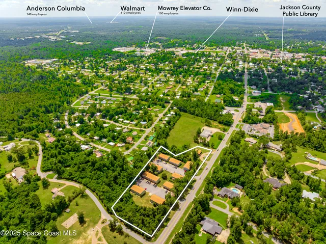 an aerial view of residential house with outdoor space and trees all around