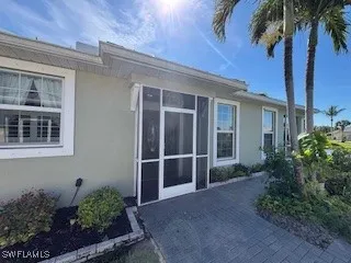 a view of a house with a yard and potted plants