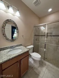 a bathroom with a granite countertop toilet sink and mirror