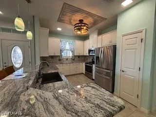 a kitchen with granite countertop a stove a refrigerator and a sink