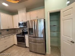 a kitchen with a refrigerator sink and cabinets