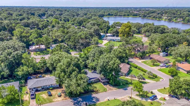 an aerial view of a houses with a yard and lake view