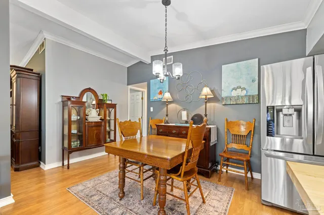 a kitchen with stainless steel appliances granite countertop a refrigerator a stove a sink a dining table and chairs