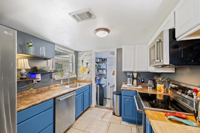 a kitchen filled counter top space a sink and appliances