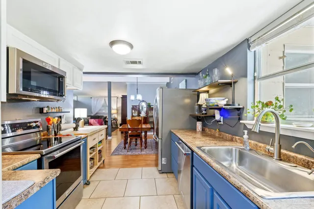 a kitchen with stainless steel appliances granite countertop a stove a sink and a microwave