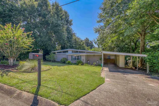 a view of a house with backyard and trees