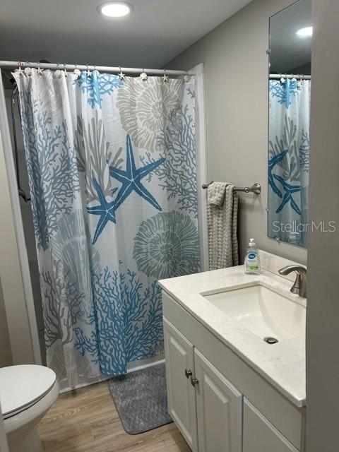 6837 Flicker Lane Hudson, FL 34667 - Photo 14 of 28 a bathroom with a sink and mirror with toilet